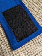 Close-up of a blue fabric belly strap with a large black hook-and-loop patch, laid on Chillybuddy's cotton mesh.